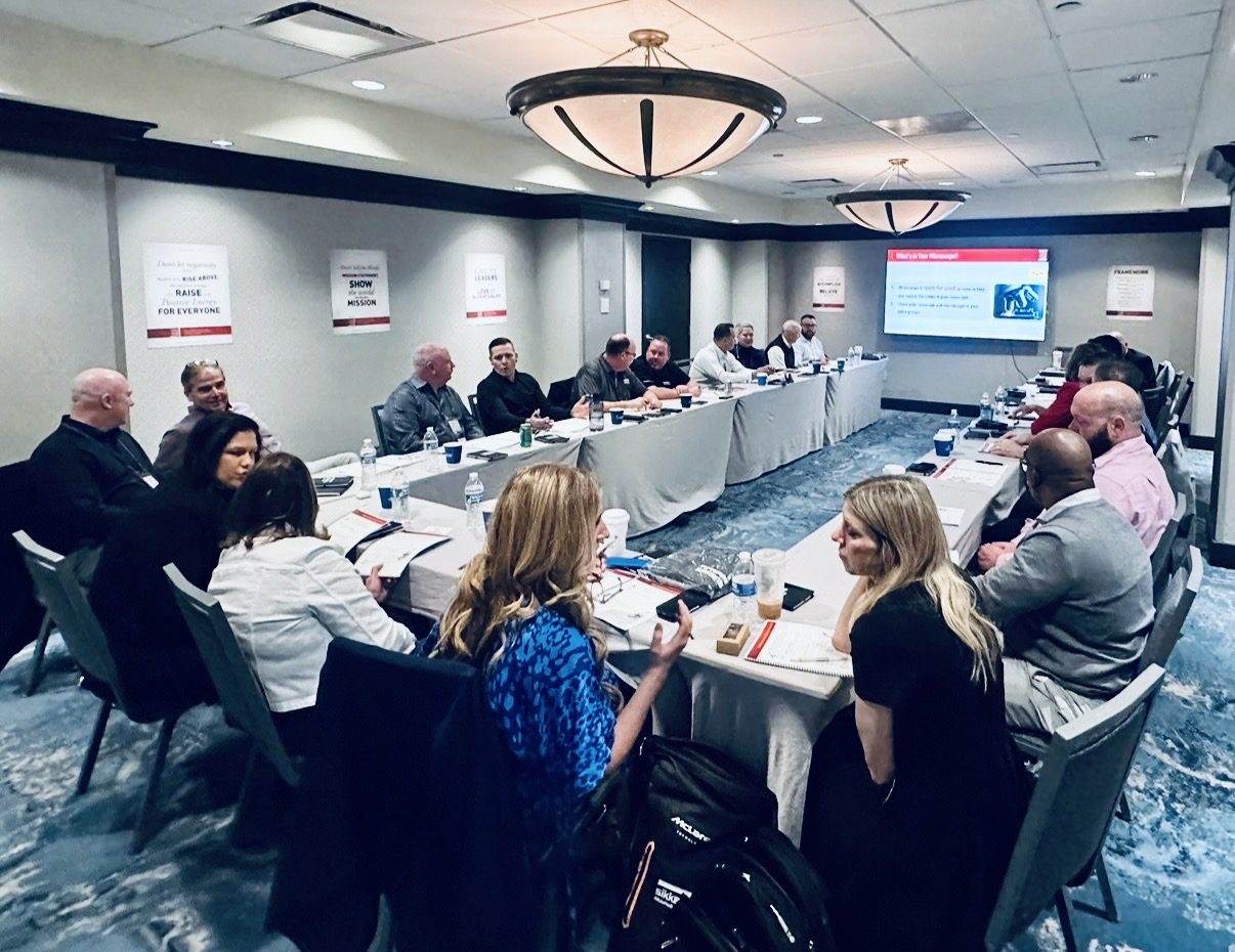 People gathered around a conference table in a professional meeting.